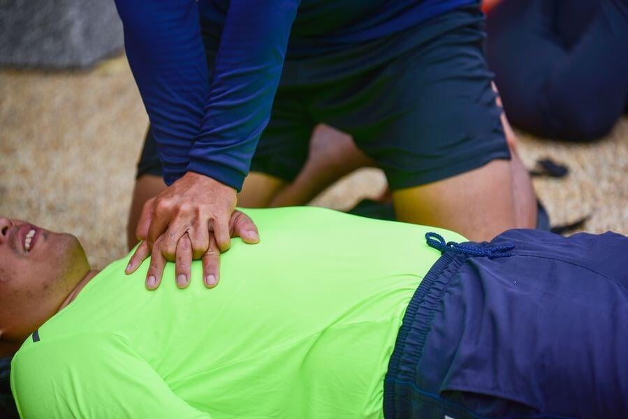 un homme fait un massage cardiaque à un autre homme